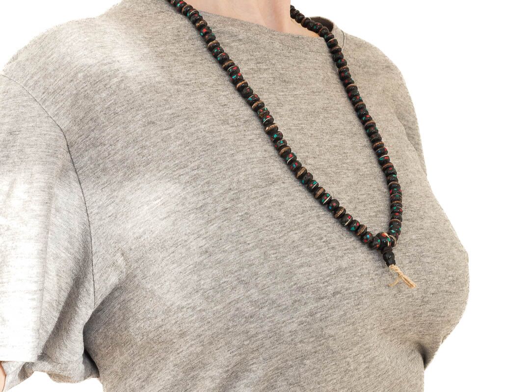 Collar de hueso teñido de negro con turquesa y coral engarzado sobre busto